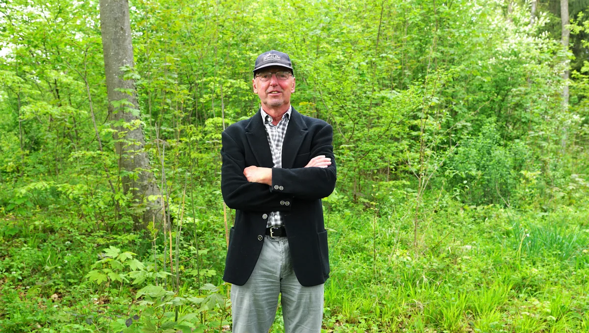 Man sieht einen Mann mit einer Schirmmütze im Wald.